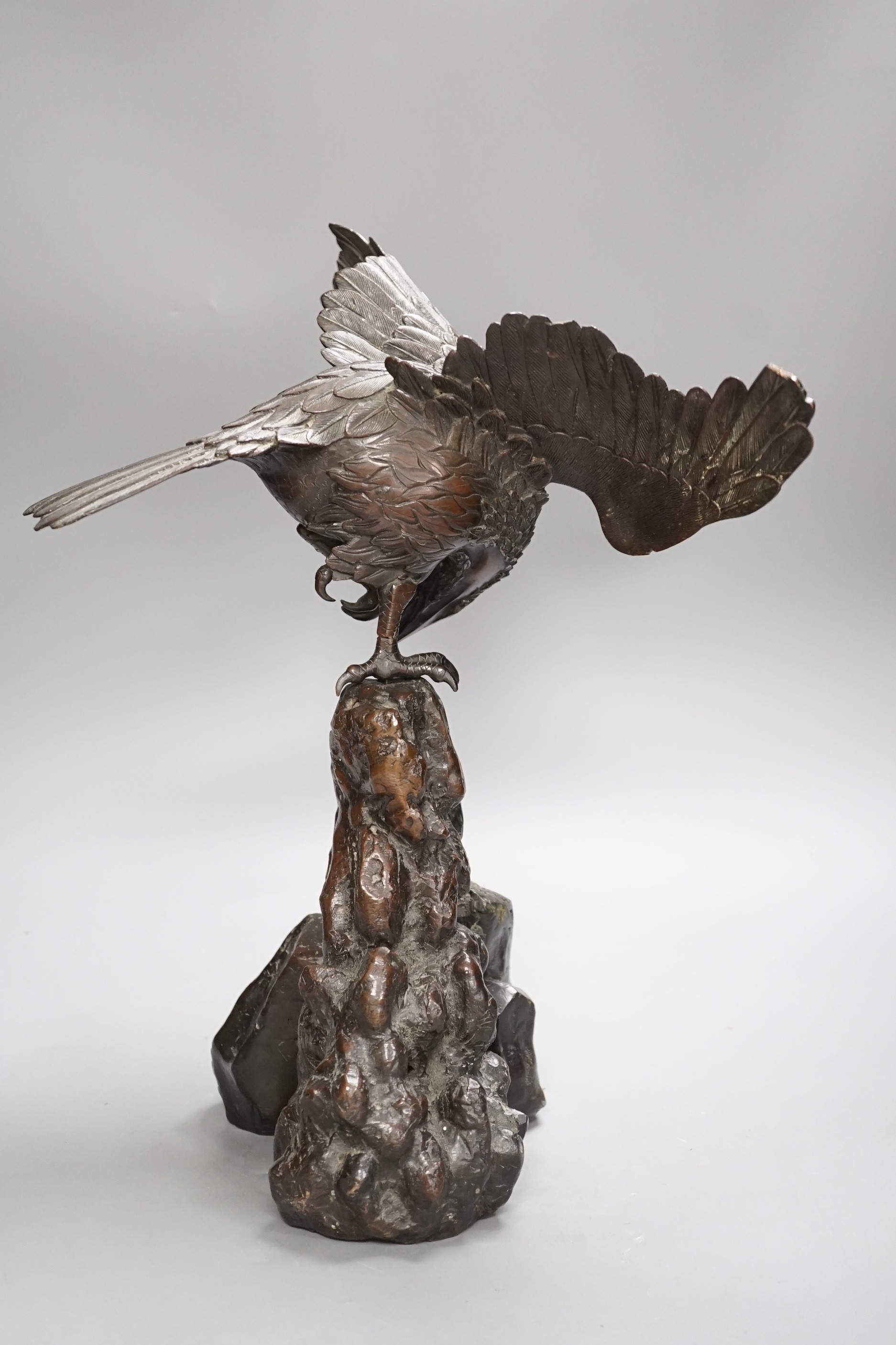 A Japanese bronze model of an eagle on a rock, Meiji period, 40cms high.